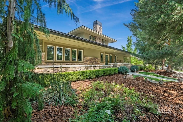356 E Lake Briar Ln, Eagle, ID 83616 - back of house featuring a chimney, stone siding, and covered porch
