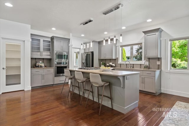 356 E Lake Briar Ln, Eagle, ID 83616 - kitchen with stainless steel appliances, gray cabinets, light countertops, a breakfast bar area, and a center island
