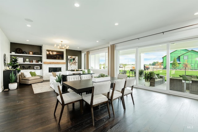 dining room with a chandelier, dark wood finished floors, recessed lighting, and a fireplace