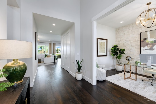 corridor with wood finished floors, a chandelier, an office area, baseboards, and recessed lighting