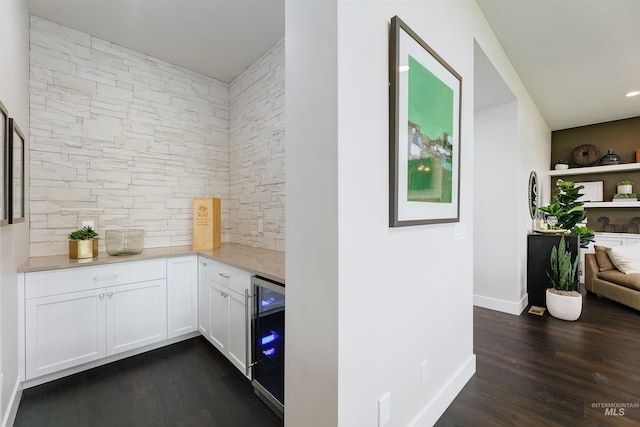 indoor dry bar with beverage cooler, dark wood-style floors, backsplash, and baseboards