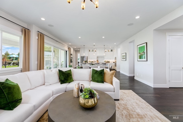 living area with dark wood finished floors, recessed lighting, baseboards, and a chandelier