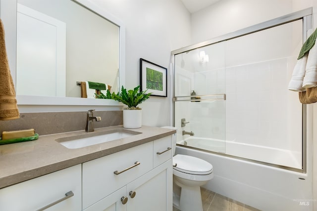 bathroom with vanity, toilet, enclosed tub / shower combo, and tile patterned flooring