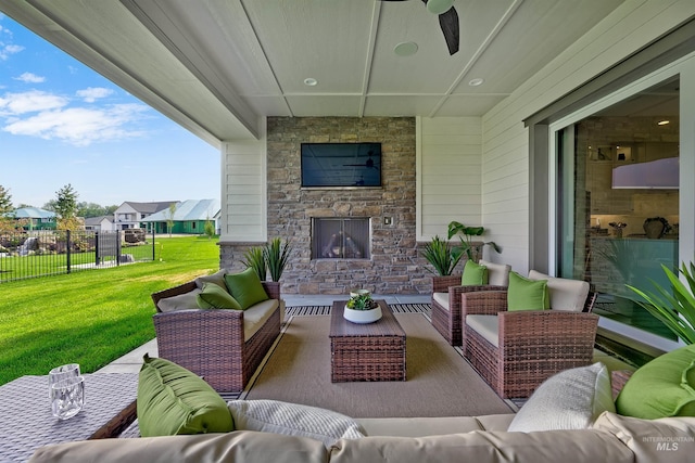 view of patio with an outdoor living space with a fireplace and ceiling fan