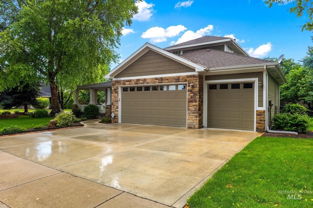 2411 S Marypost, Eagle, ID 83616 - craftsman house featuring stone siding, a garage, concrete driveway, a front lawn, and roof with shingles