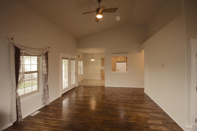 unfurnished living room featuring ceiling fan, dark wood-style floors, french doors, baseboards, and high vaulted ceiling