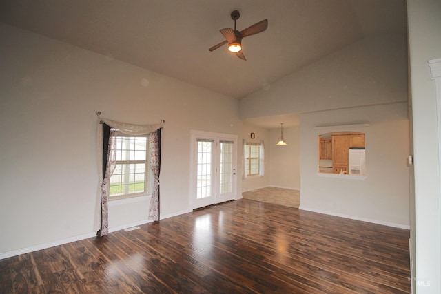 unfurnished living room featuring a ceiling fan, wood finished floors, high vaulted ceiling, and baseboards