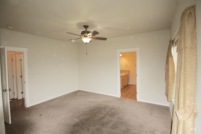 unfurnished bedroom with carpet flooring, baseboards, ensuite bath, and ceiling fan