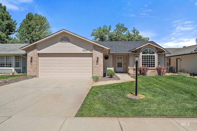 8520 W Willowcourt Dr, Boise, ID 83714 - single story home with brick siding, a garage, a front yard, driveway, and central air condition unit