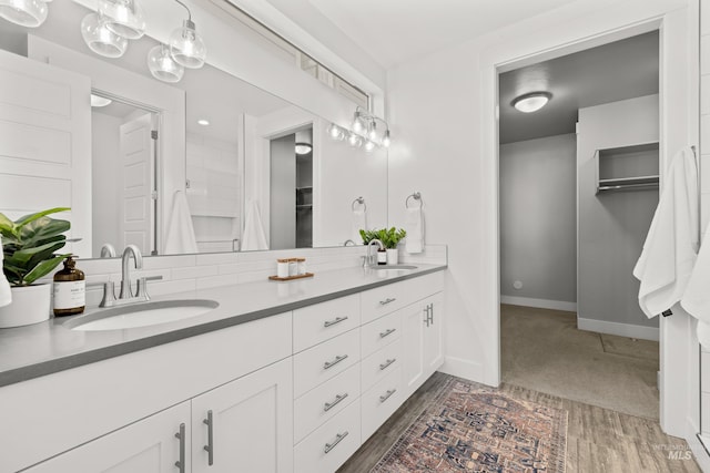 10148 Irongate Dr, Nampa, ID 83687 - bathroom with double vanity, baseboards, wood finished floors, and a sink