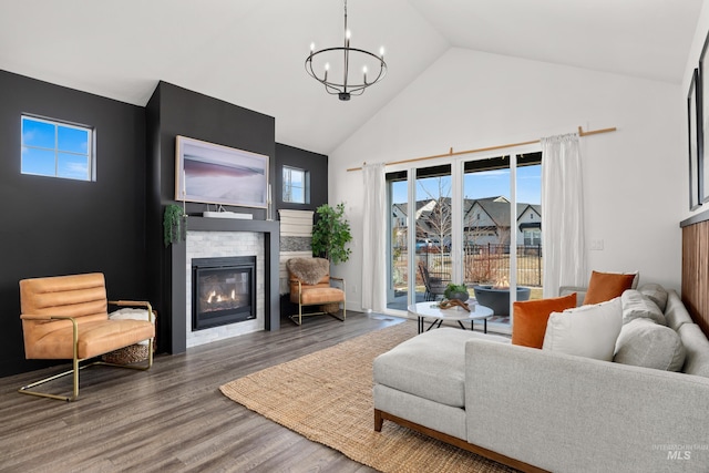 10148 Irongate Dr, Nampa, ID 83687 - living area with a glass covered fireplace, wood finished floors, high vaulted ceiling, and an inviting chandelier