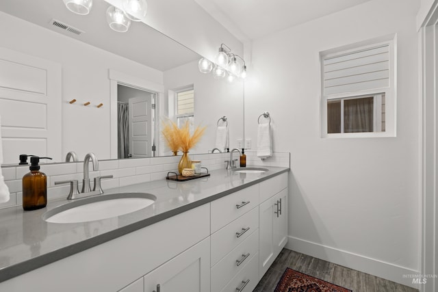 10148 Irongate Dr, Nampa, ID 83687 - full bath featuring wood finished floors, a sink, visible vents, and double vanity