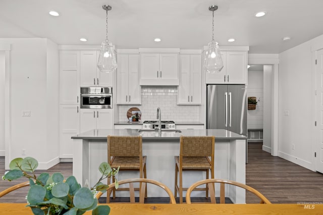 10148 Irongate Dr, Nampa, ID 83687 - kitchen with dark wood finished floors, baseboards, recessed lighting, white cabinetry, and appliances with stainless steel finishes