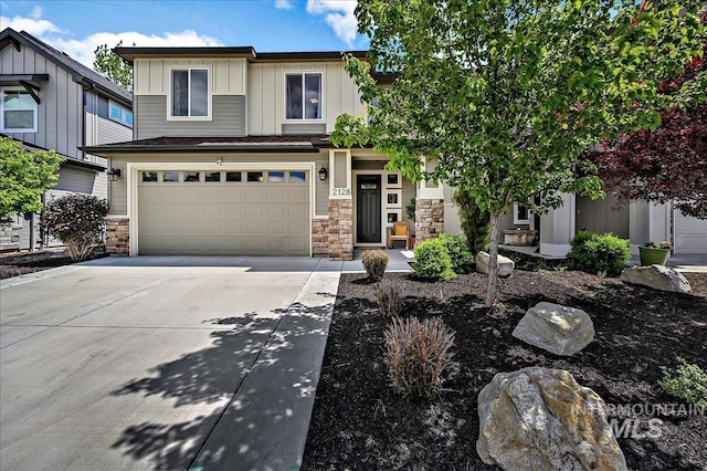 2128 N Woodcreek St, Boise, ID 83704 - view of front of house with stone siding, concrete driveway, a garage, and board and batten siding