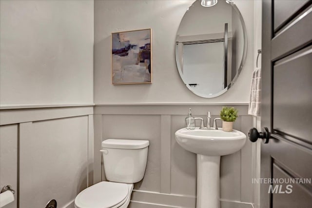 2128 N Woodcreek St, Boise, ID 83704 - half bathroom with toilet, a decorative wall, and a sink