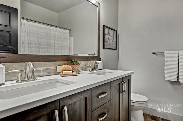 2128 N Woodcreek St, Boise, ID 83704 - bathroom featuring double vanity, toilet, wood finished floors, and tasteful backsplash