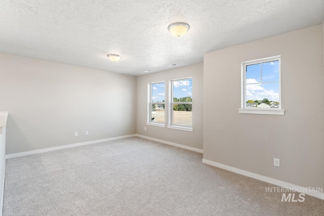 carpeted spare room featuring a textured ceiling