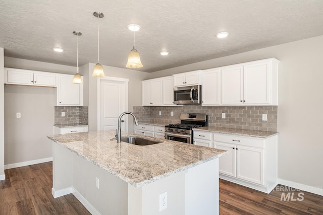 kitchen featuring hanging light fixtures, a center island with sink, stainless steel appliances, and sink