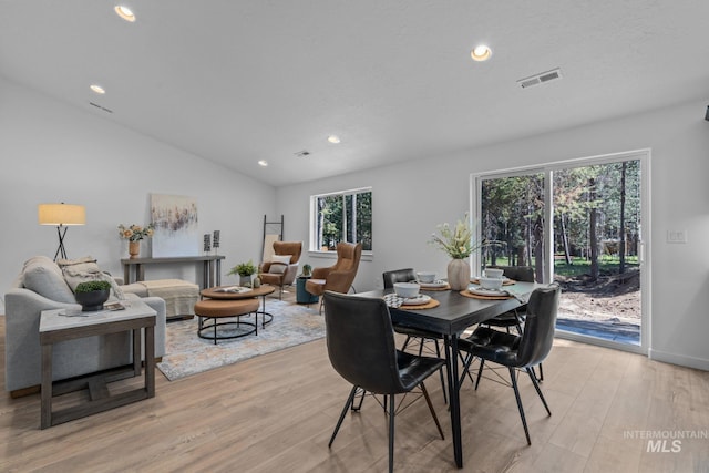 dining space featuring lofted ceiling, light wood finished floors, visible vents, and recessed lighting