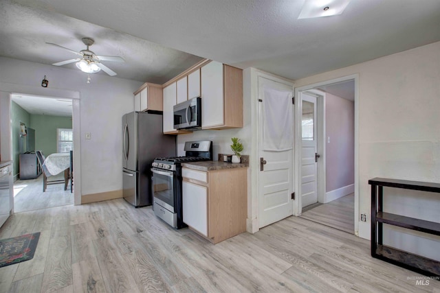 412 6th Ave N, Twin Falls, ID 83301 - kitchen featuring stainless steel appliances, light wood finished floors, ceiling fan, light brown cabinetry, and a textured ceiling