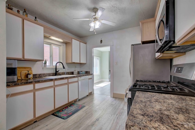 412 6th Ave N, Twin Falls, ID 83301 - kitchen with white dishwasher, light wood-style floors, stainless steel gas range oven, a ceiling fan, and healthy amount of natural light