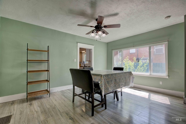 412 6th Ave N, Twin Falls, ID 83301 - dining room featuring light wood-style floors, a textured ceiling, and ceiling fan