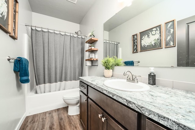 full bathroom featuring toilet, shower / bath combo with shower curtain, wood finished floors, and vanity