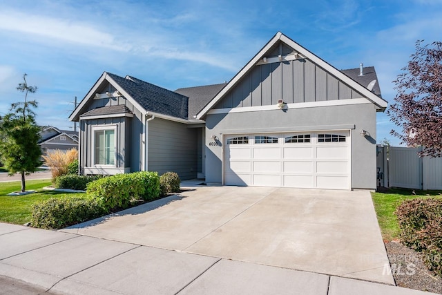 view of front facade featuring a garage, fence, driveway, roof with shingles, and board and batten siding