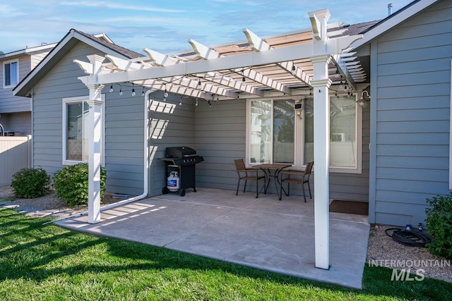 view of patio with fence, area for grilling, and a pergola