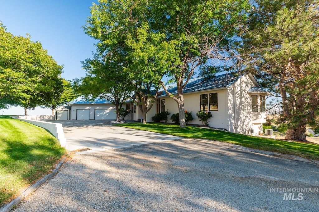 single story home with driveway, a front lawn, and stucco siding