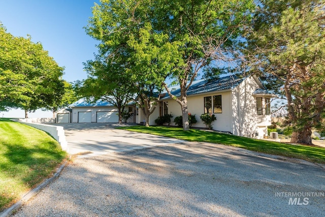 single story home with driveway, a front lawn, and stucco siding