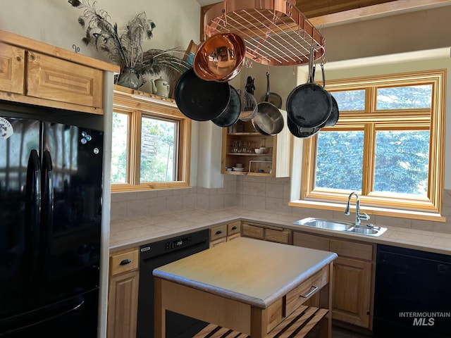 kitchen featuring backsplash, black appliances, light brown cabinetry, and sink