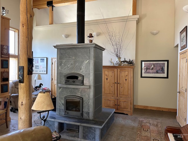 living room featuring a high ceiling, a tile fireplace, and concrete floors