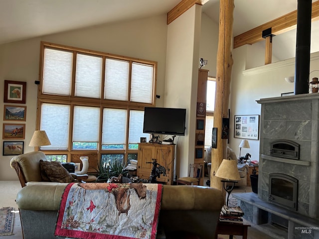 living room with a tiled fireplace, beam ceiling, high vaulted ceiling, and a wealth of natural light