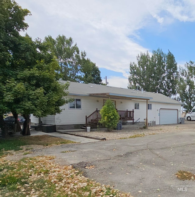 view of front of house with a wooden deck, central air condition unit, and a garage