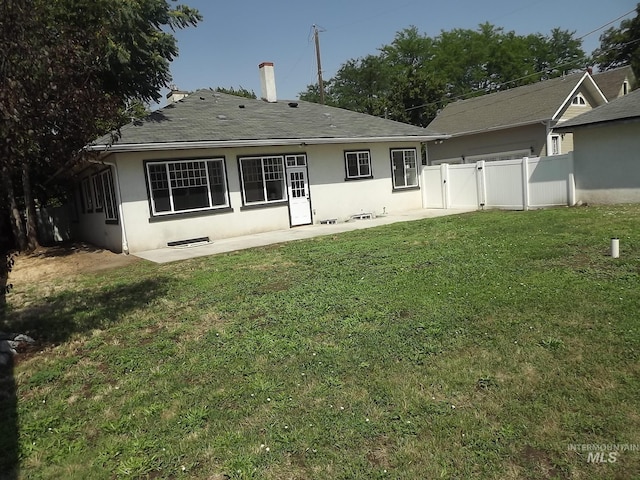 rear view of property featuring a lawn