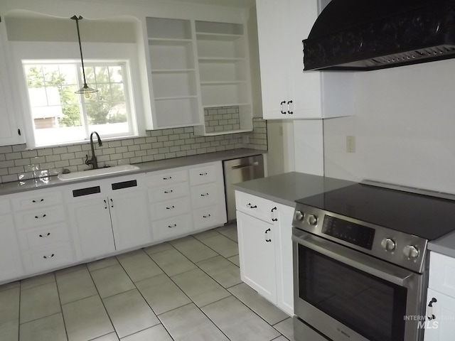 kitchen with pendant lighting, sink, appliances with stainless steel finishes, white cabinetry, and premium range hood