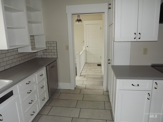 kitchen with light tile patterned flooring, sink, white dishwasher, decorative backsplash, and white cabinetry