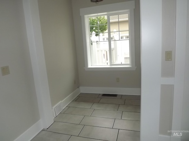 unfurnished dining area featuring light tile patterned floors