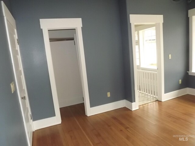 unfurnished bedroom featuring a closet and hardwood / wood-style flooring