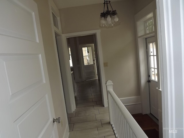 interior space featuring plenty of natural light, a notable chandelier, and light tile patterned floors