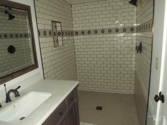 bathroom featuring a tile shower and vanity