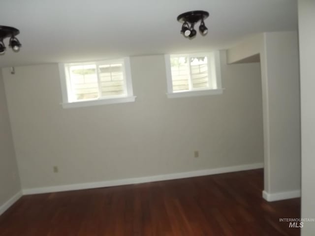 basement featuring plenty of natural light and dark hardwood / wood-style floors