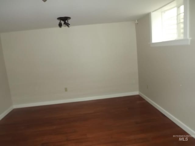 unfurnished room with dark hardwood / wood-style flooring