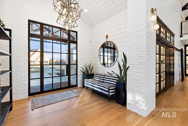 foyer featuring a wealth of natural light, wood-type flooring, and high vaulted ceiling