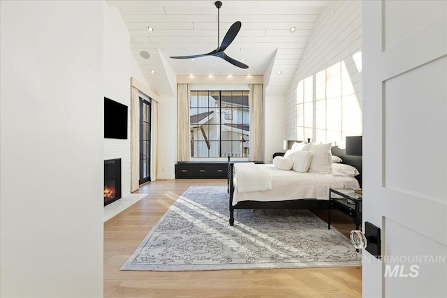 bedroom featuring wooden ceiling, lofted ceiling, light hardwood / wood-style floors, and ceiling fan