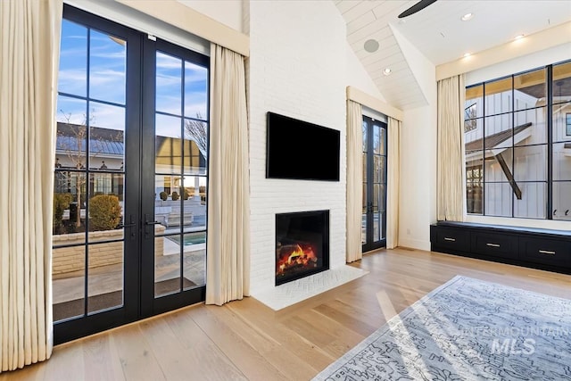 living room featuring french doors, wood-type flooring, and a fireplace