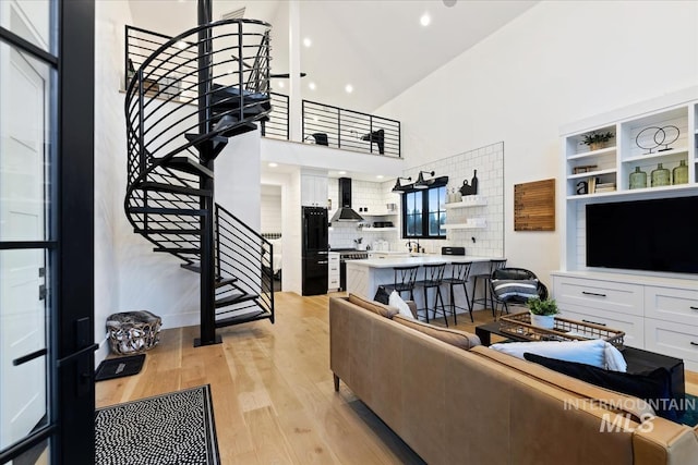 living room featuring light hardwood / wood-style floors and a towering ceiling