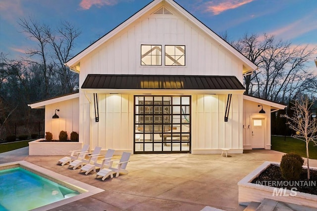 back house at dusk featuring a patio