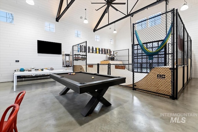 game room with concrete floors, pool table, a healthy amount of sunlight, and high vaulted ceiling